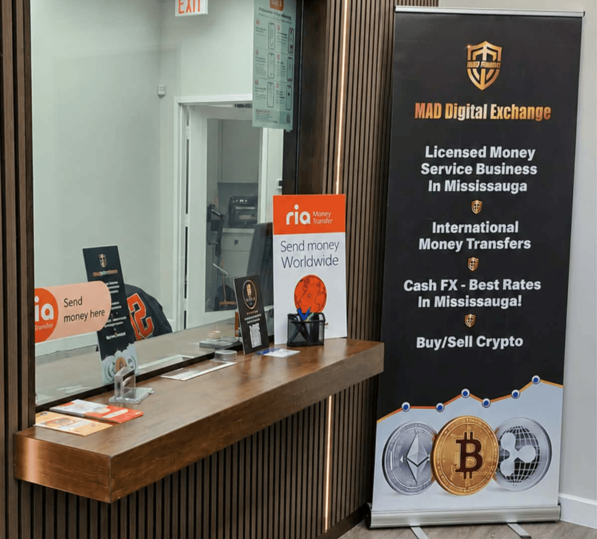 Money transfer service counter with crypto exchange banner inside a modern office